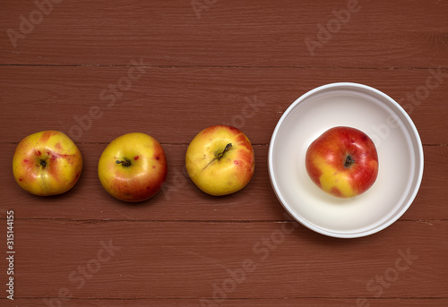 apples from the store in a white cup, on a brown background, large top