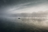 Lonely man fishing on the foggy river