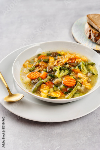 Light and healthy vegetable soup on grey bavkground