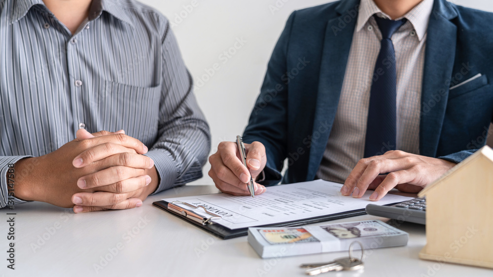 Real estate agent are presenting home loan and giving house to customer after signing contract to buy house with approved property application form Real estate agent are presenting home loan and giving house to customer after signing contract to buy house with approved property application form