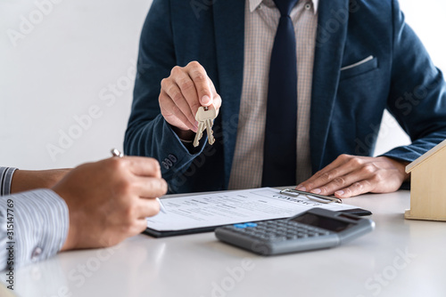 Real estate agent are presenting home loan and sending keys to customer after signing contract to buy house with approved property application form, Insurance Home concept