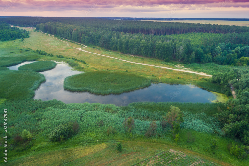 Aerial view of countryside and lake in the evening at sunset light. Beautiful nature landscape