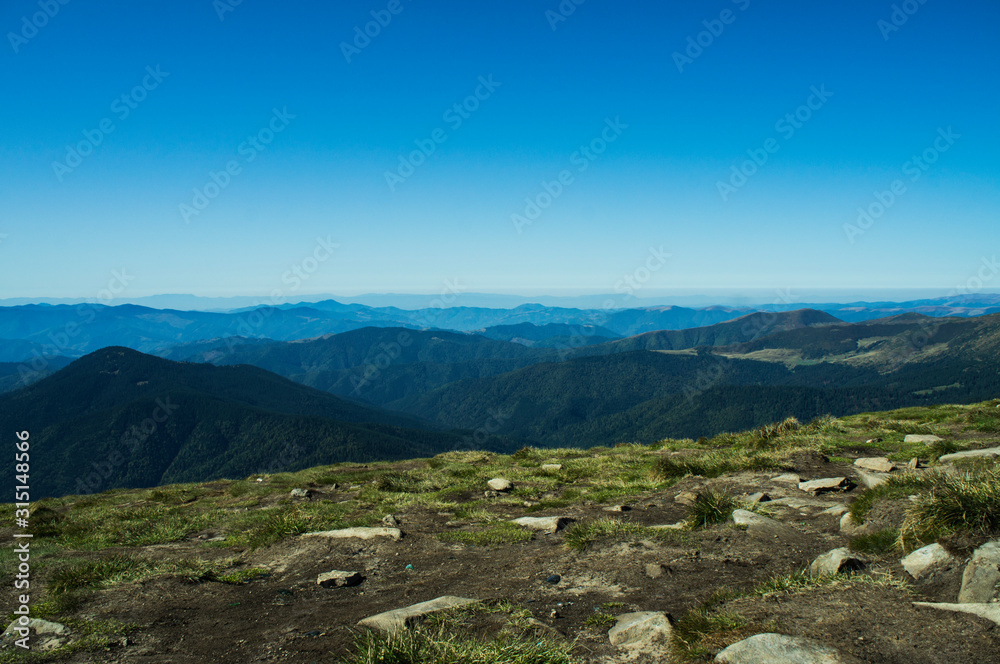 Colorful mountain landscape in the summer mountains. Large hills with blue sky.