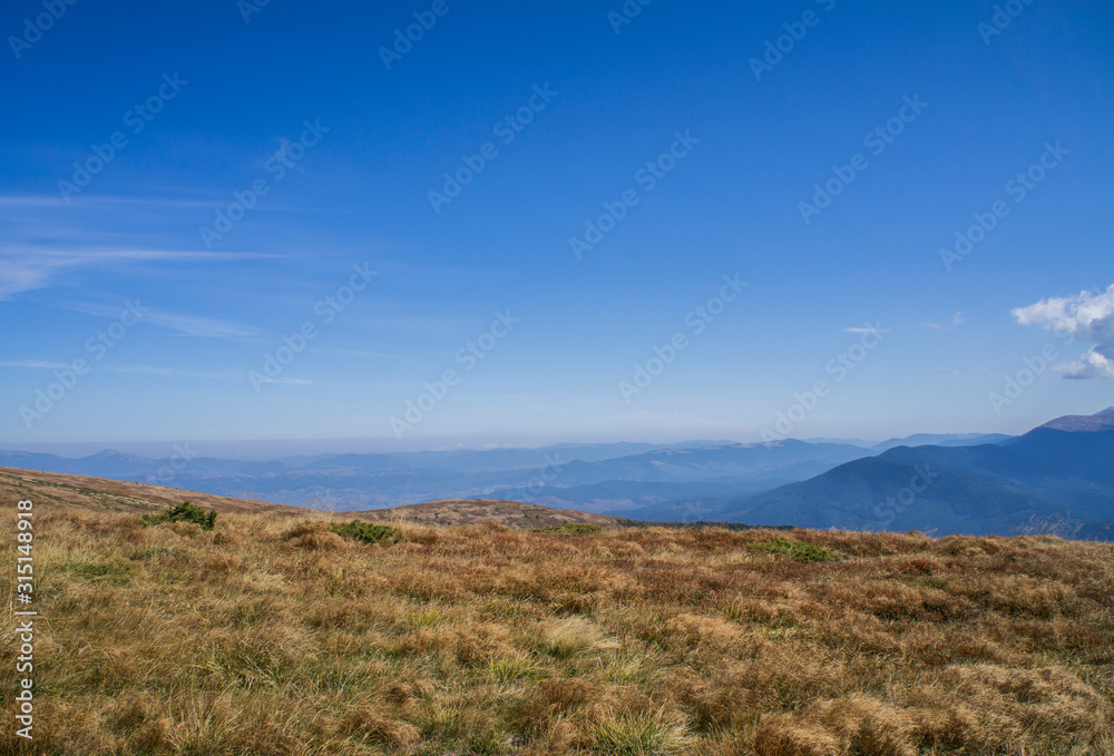 Colorful mountain landscape in the summer mountains. Large hills with blue sky.