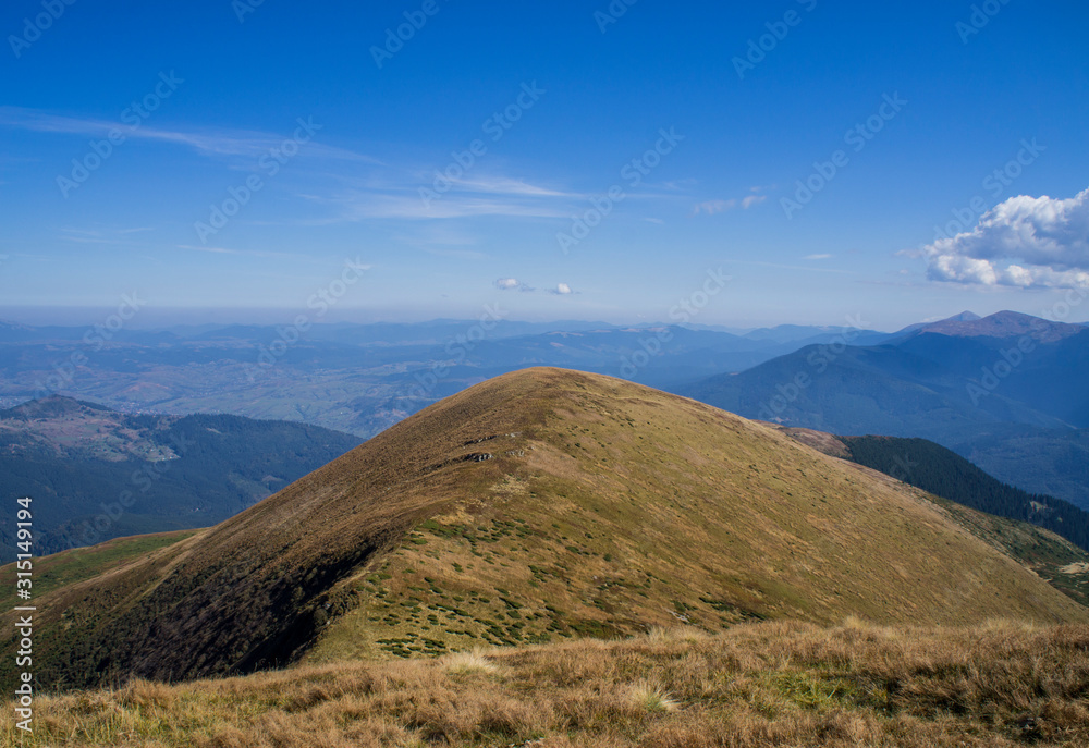 Fototapeta premium Colorful mountain landscape in the summer mountains. Large hills with blue sky.