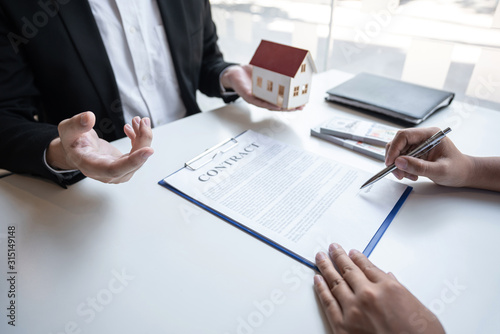 Real estate agent are presenting home loan and sending keys to customer after signing contract to buy house with approved property application form, Insurance Home concept