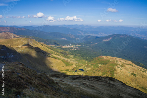 Colorful mountain landscape in the summer mountains. Large hills with blue sky. © Payllik