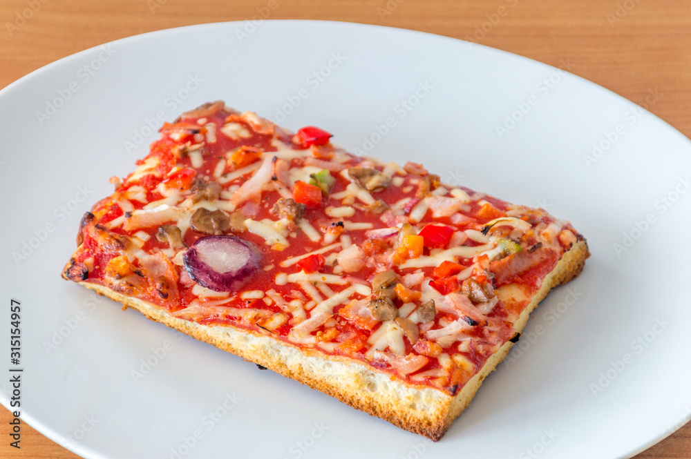 Baked cheap frozen pizza on a white plate. Baked cheap frozen pizza on a white plate.