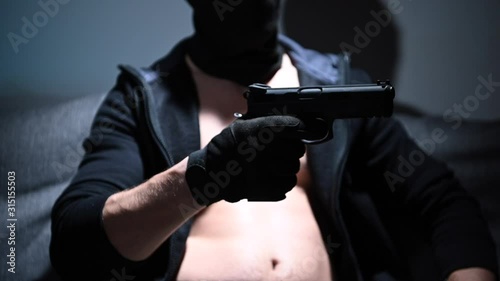 Slow Motion Footage of Caucasian Felon with Handgun in a Hand. Crime Theme. photo