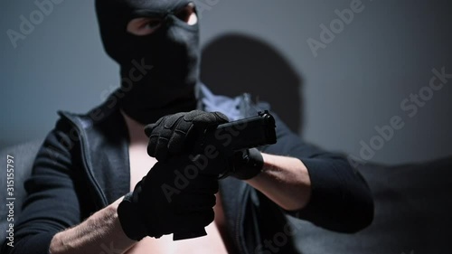 Slow Motion Footage of Masked Gang Member in His 30s. Playing with Handgun. 