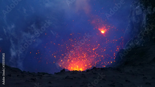CLOSE UP: Active volcano in the Pacific spewing out the glowing orange lava.