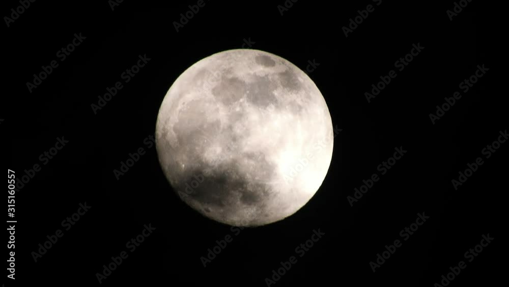 Clouds passing by moon at night. Full moon at night with clouds in real time. Clouds passing by moon at night. Full moon at night with clouds in real time.