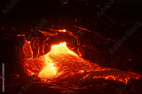 Detailed view of an active lava flow, hot magma emerges from a crack in the earth, the glowing lava appears in strong yellows and reds - Hawaii, Big Island, Kilauea volcano, Puna district, Kalapana photo