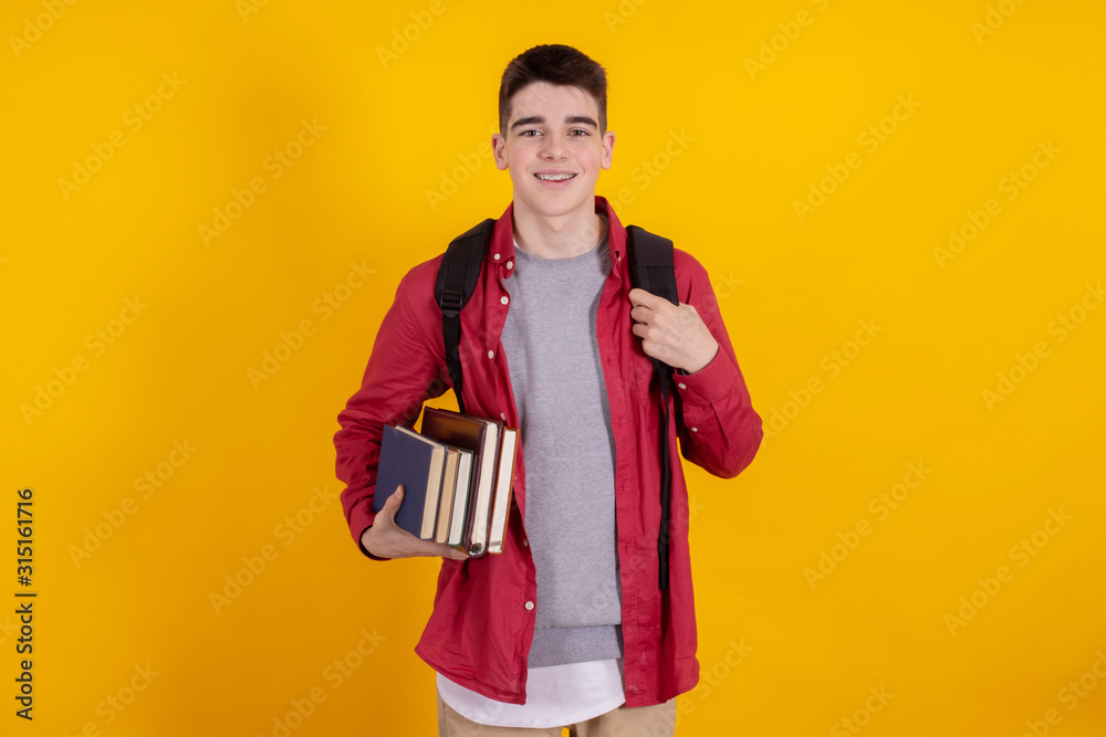 teenage student with books and school or university backpack isolated on color background