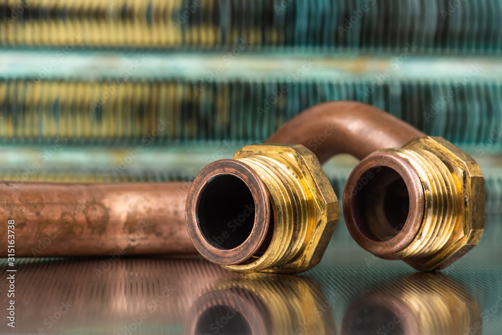 Plumbing brass and copper part on metallic workshop table, old item after service and repair Plumbing brass and copper part on metallic workshop table, old item after service and repair