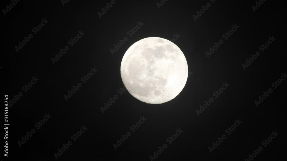 Clouds passing by moon at night. Full moon at night with clouds in real time.
