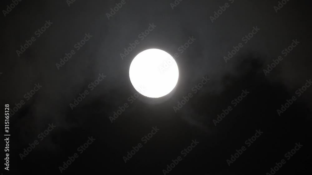 Clouds passing by moon at night. Full moon at night with clouds in real time. Clouds passing by moon at night. Full moon at night with clouds in real time.
