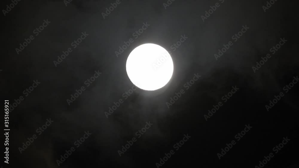 Clouds passing by moon at night. Full moon at night with clouds in real time. Clouds passing by moon at night. Full moon at night with clouds in real time.