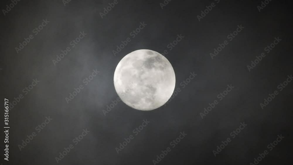 Clouds passing by moon at night. Full moon at night with clouds in real time. Clouds passing by moon at night. Full moon at night with clouds in real time.