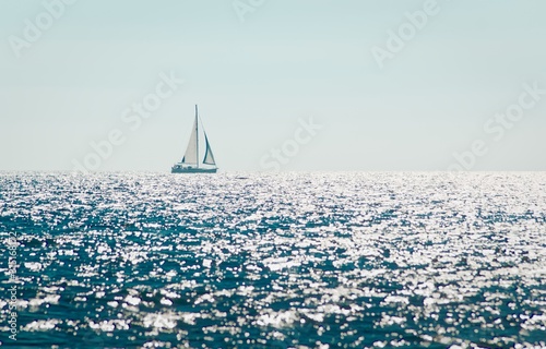 Sailing sailboat on blue sea horizon