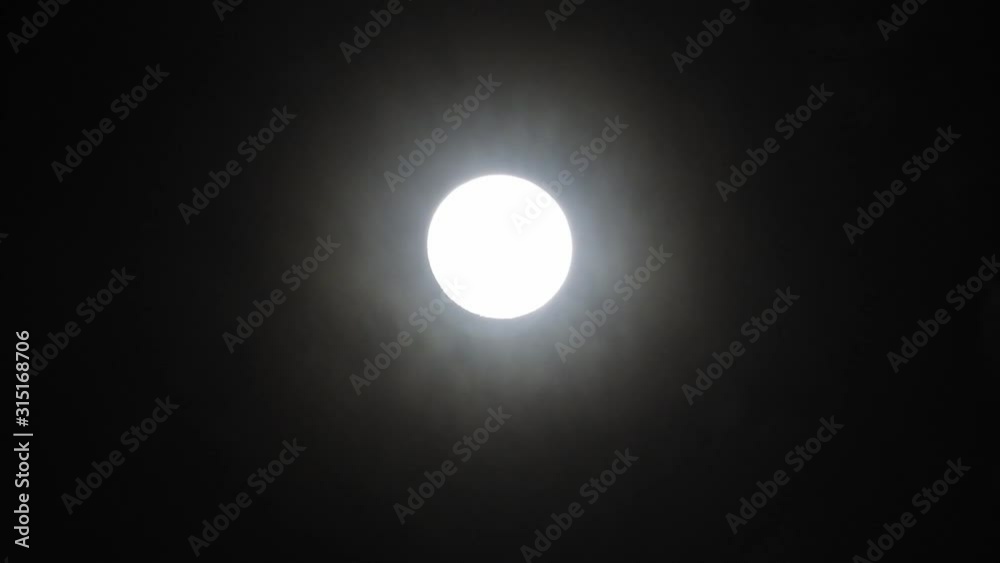 Clouds passing by moon at night. Full moon at night with clouds in real time. Clouds passing by moon at night. Full moon at night with clouds in real time.