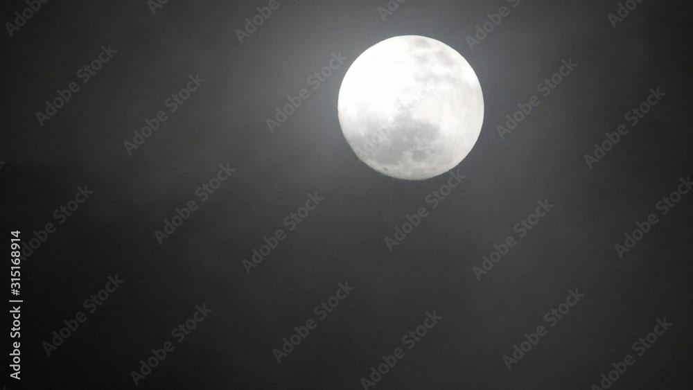 Clouds passing by moon at night. Full moon at night with clouds in real time.