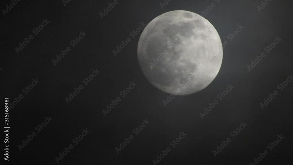 Clouds passing by moon at night. Full moon at night with clouds in real time. Clouds passing by moon at night. Full moon at night with clouds in real time.