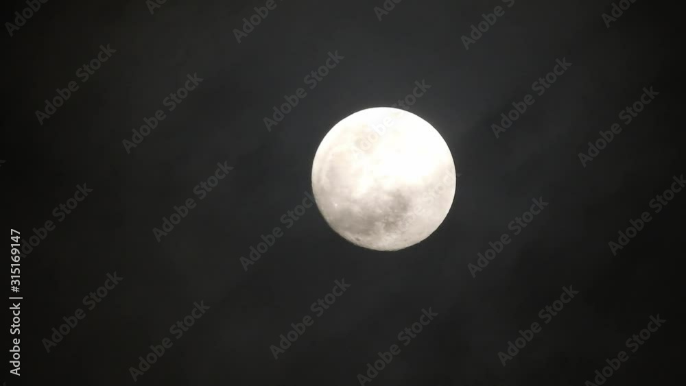 Clouds passing by moon at night. Full moon at night with clouds in real time. Clouds passing by moon at night. Full moon at night with clouds in real time.