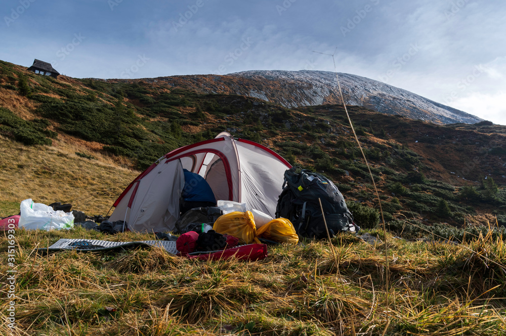 Tourist tent and things. Tourist collects things. Hiker in the mountains.