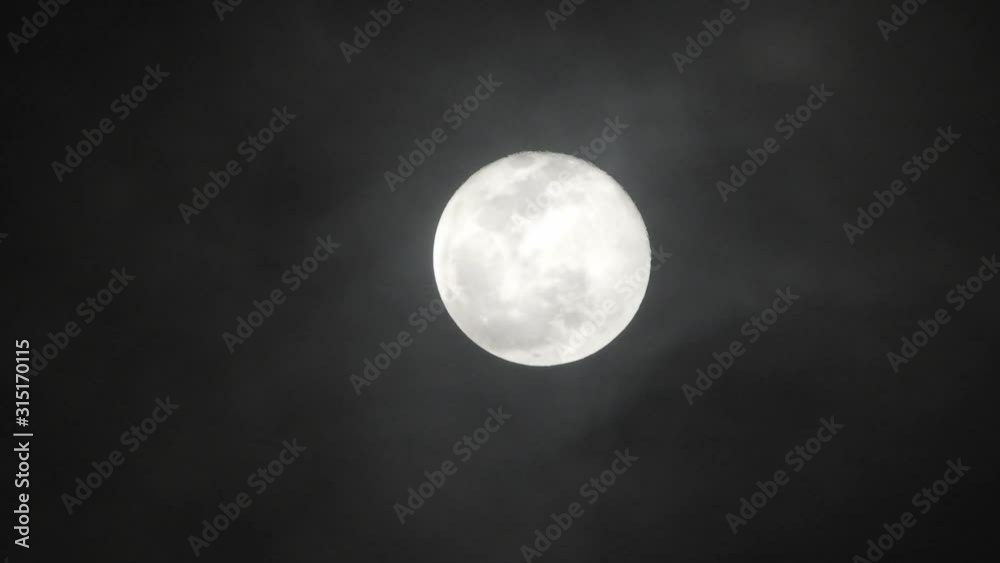 Clouds passing by moon at night. Full moon at night with clouds in real time. Clouds passing by moon at night. Full moon at night with clouds in real time.