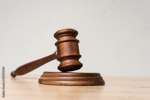 selective focus of gavel on wooden desk isolated on grey