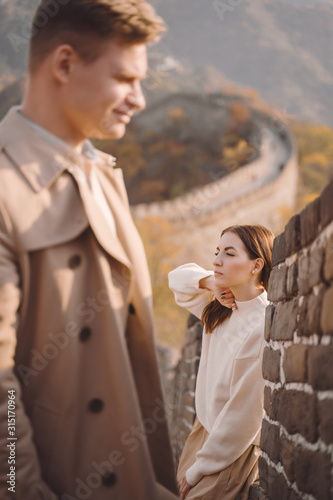 beautiful young couple posing at the Great Wall of China. Newly married couple on their honemoon to Great Wall near Beijing China. Stylish couple exploring one of the wonders of the world. photo