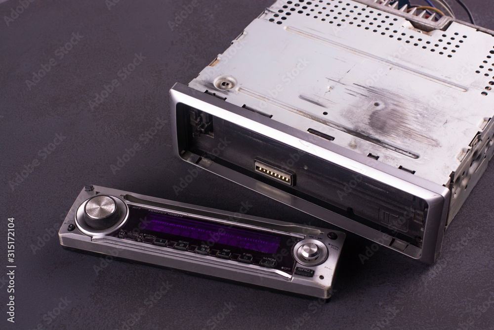 Old disk car radio with a removable panel on a black background. Old disk car radio with a removable panel on a black background.