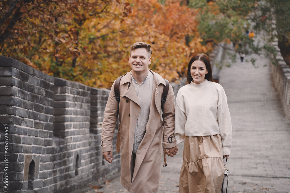 young couple holding hands as they are walking at the Great Wall of China.Newly married couple on their honeymoon to the Great Wall of China near Beijing China. young couple holding hands as they are walking at the Great Wall of China.Newly married couple on their honeymoon to the Great Wall of China near Beijing China.