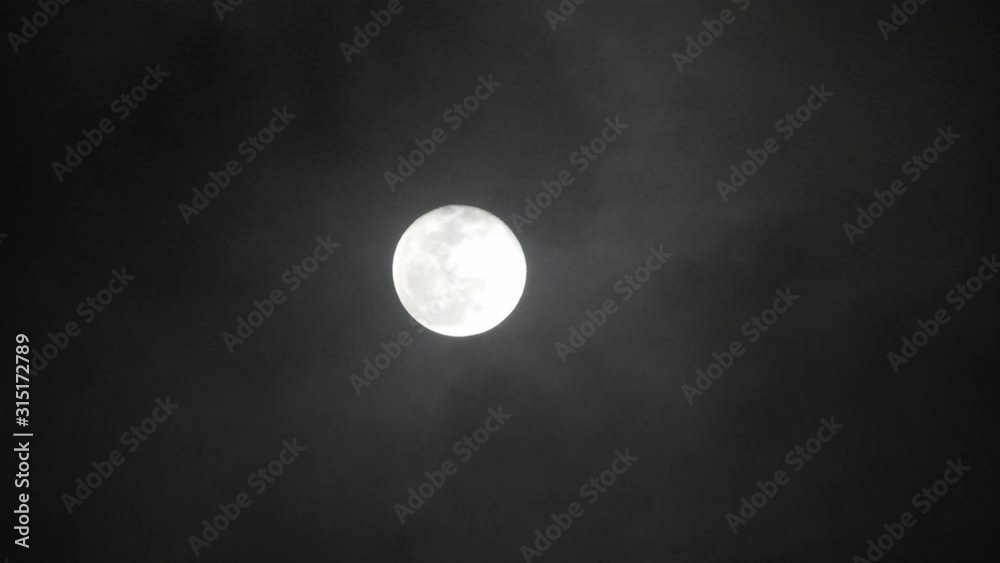 Full moon on dark cloudy night. Clouds passing by the moon, real time shot. Full moon on dark cloudy night. Clouds passing by the moon, real time shot.