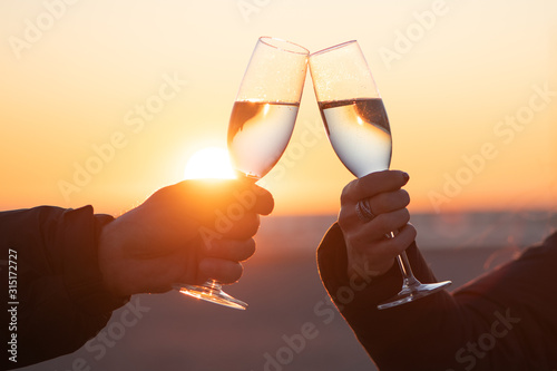 man and woman with glass of wine at sunset