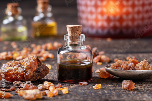 Fotografiet Myrrh essential oil with myrrh resin on a table