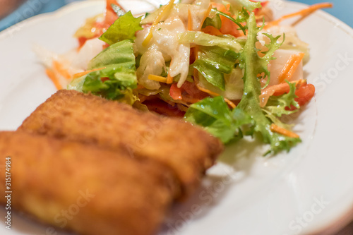 Potato croquette filled with cheese and herbs served with fresh green salad, tomatoes and pepper