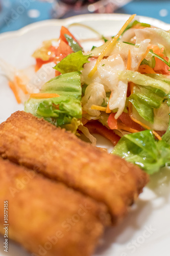 Potato croquette filled with cheese and herbs served with fresh green salad, tomatoes and pepper