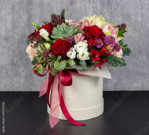 fresh arrangement of bright flowers in a hat box florist work place for text