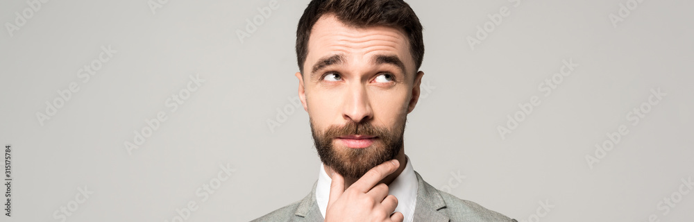 Fototapeta premium panoramic shot of thoughtful businessman holding hand near face and looking away