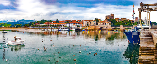 San Vicente de la barquera village in Cantabria,Spain.Scenic medieval village ,mountain and sea panoramic landscape in northern Spain.Green meadows and boats in the port