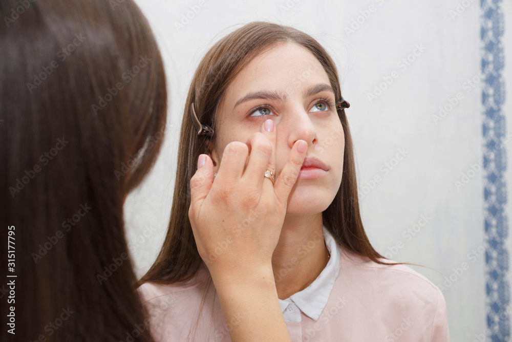 Makeup artist aligns tonal crem on the face of the model. Makeup artist aligns tonal crem on the face of the model.