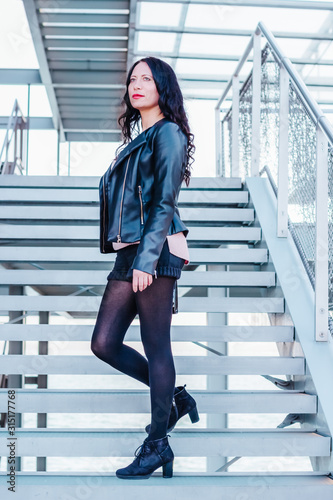 Beautiful urban woman posing on metal stairs outdoors
