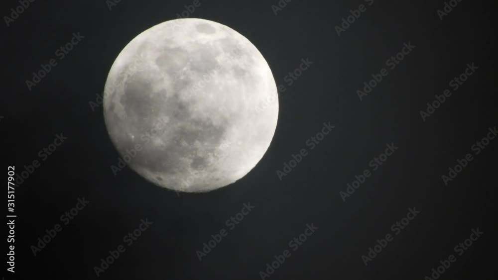 Full moon on dark cloudy night. Clouds passing by the moon, real time shot. Full moon on dark cloudy night. Clouds passing by the moon, real time shot.