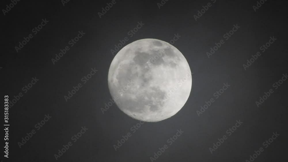 Full moon on dark cloudy night. Clouds passing by the moon, real time shot. Full moon on dark cloudy night. Clouds passing by the moon, real time shot.