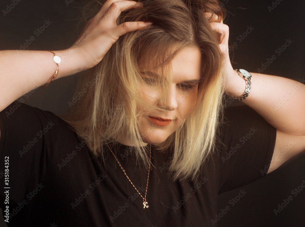 Obraz premium blonde Plus Size Model on black background in dark clothes