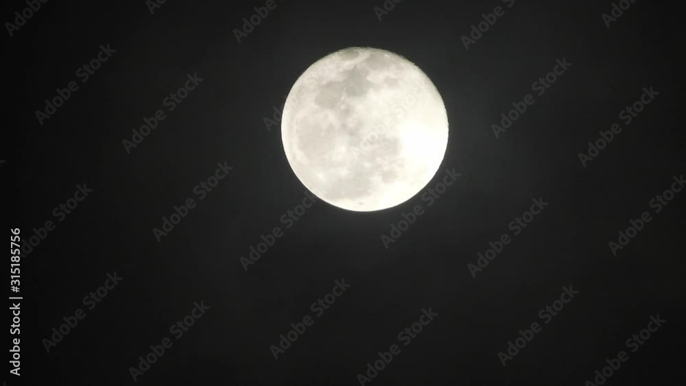 Full moon on dark cloudy night. Clouds passing by the moon, real time shot. Full moon on dark cloudy night. Clouds passing by the moon, real time shot.