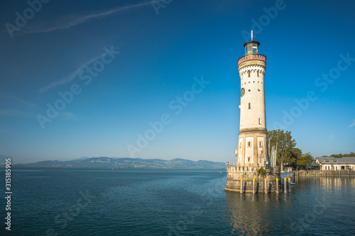 Historic lighthouse in the harbor of Lindau, Bavaria. A city in Germany, on an island in the middle of Lake Constance. Alps in the background