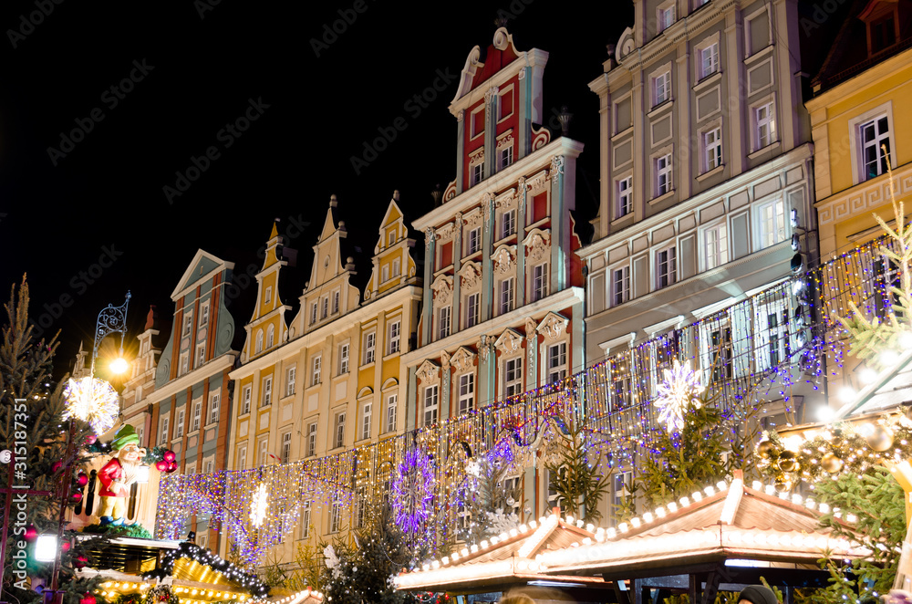 Naklejka premium Festive Market of Rynek Square Against Traditional Colorful Old Buildings.